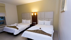 A hotel room with two beds, a large headboard, and a wall-mounted TV. - Hotel Ave Inn Mazatlán (Mazatlán)