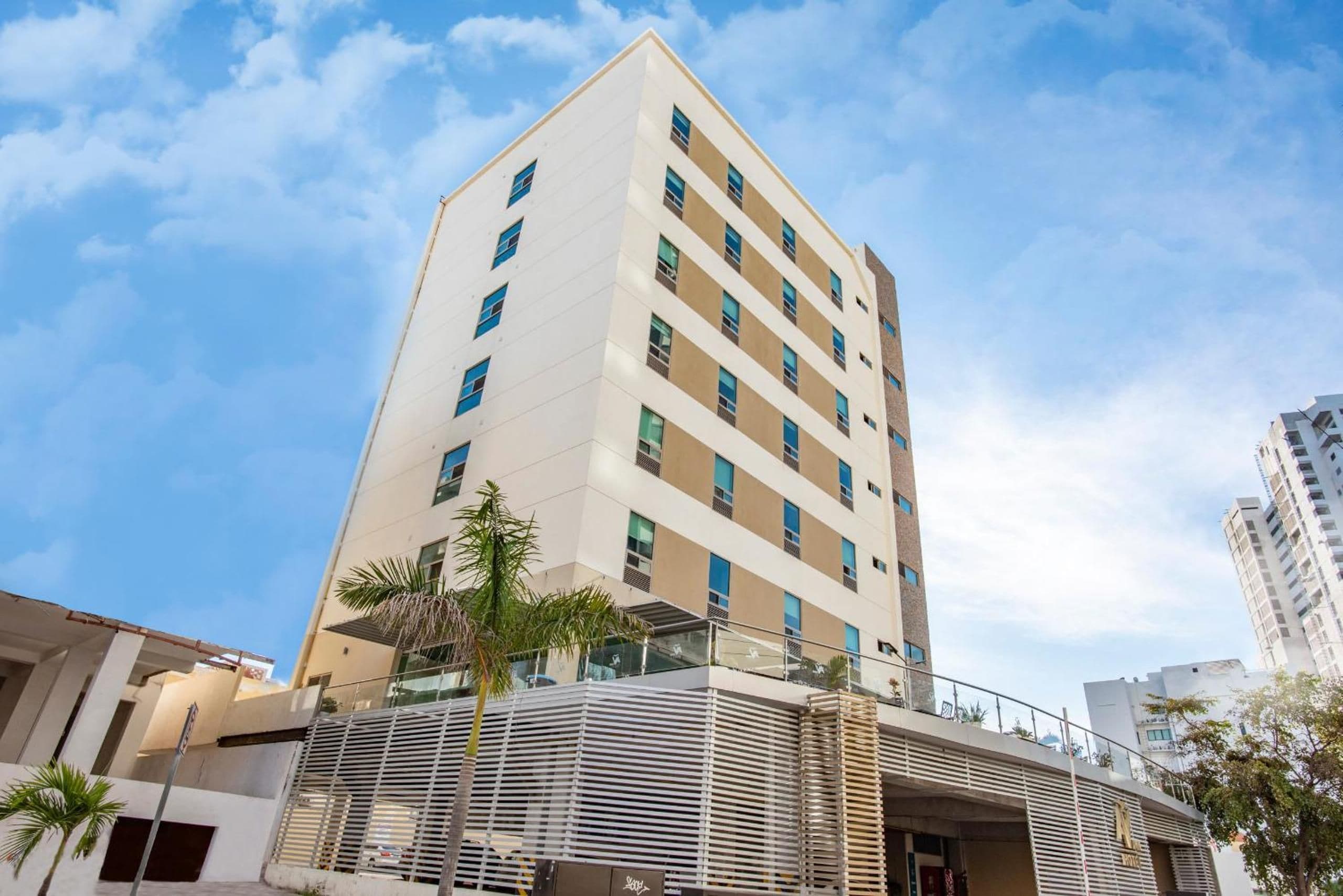 Ein mehrstöckiges Hotel mit modernem Design, das ein Flachdach und mehrere Balkons hat.