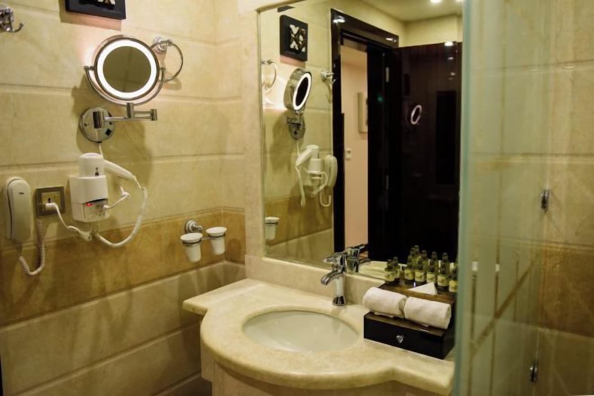 A bathroom with a sink, mirror, and a glass shower enclosure.