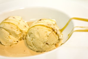 Un tazón de helado de vainilla con salsa de caramelo.