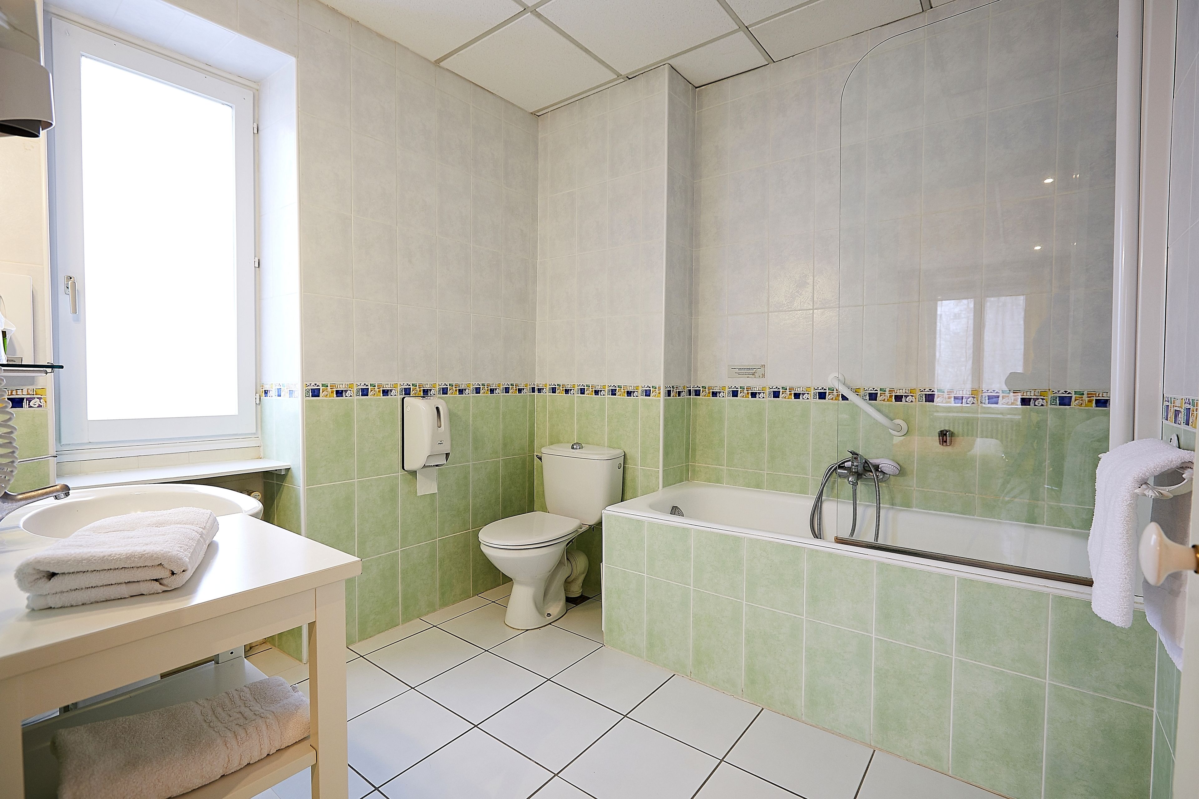 A bathroom with a toilet, sink, and bathtub.