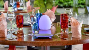 A dining table set with various glassware and napkins.