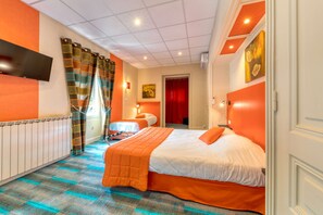 Habitación de hotel con una cama grande, un televisor de pantalla plana en la pared y una ventana con cortinas.