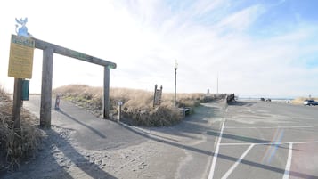 A parking area with a wooden signpost and a lamp post.
