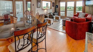 A spacious living area with a dining table, chairs, and a red sofa. - Beach Haven (Ocean Park)