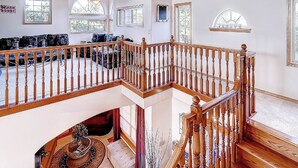 A spacious living area with a wooden staircase, a sofa set, and a decorative fountain. - Beach Haven (Ocean Park)