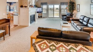 A spacious living room with a fireplace, a dining area, and a view of the outdoors. - Beachwood Estate (Ocean Park)
