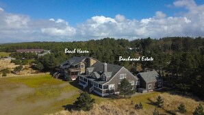 A large estate with multiple buildings, including a main house and a guest house, surrounded by dense forest and open fields. - Beachwood Estate (Ocean Park)