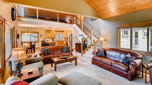 A spacious living room with a fireplace, a dining area, and a kitchen. - Cascade Mountain Villa (Cle Elum)
