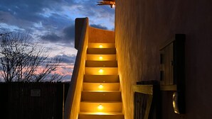 A staircase with illuminated steps leading up to a building. - Casa Mono (Santa María Tonameca)