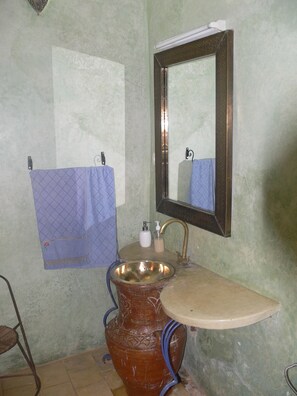 A bathroom with a sink, mirror, and towel rack.