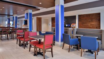 A modern restaurant interior with booths and tables, wooden flooring, and a coffee bar area.