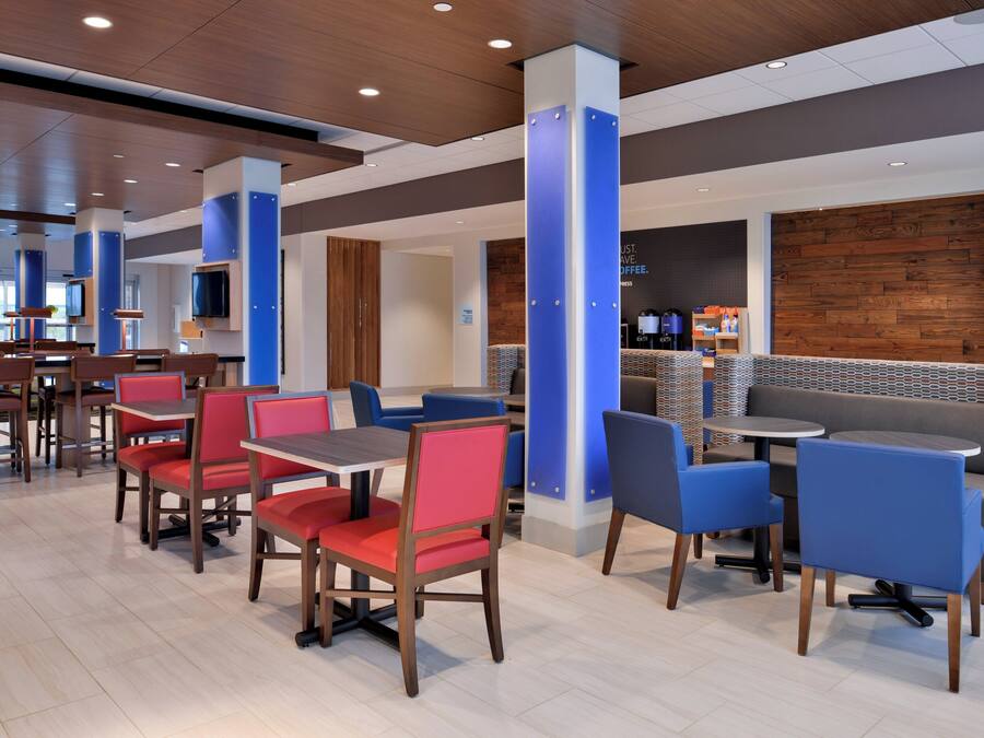 A modern restaurant interior with booths and tables, wooden flooring, and a coffee bar area.