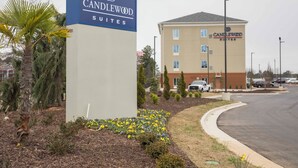 Een hotelsign voor Candlewood Suites met een modern gebouw op de achtergrond.