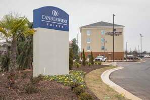 Une enseigne d’hôtel pour Candlewood Suites, avec un bâtiment moderne en arrière-plan.