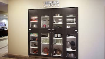 A lending locker with various items inside, including a blender, a coffee maker, and a microwave.