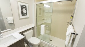 Une salle de bain moderne avec une douche à parois de verre, des toilettes et un lavabo.