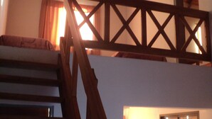 A staircase with wooden railings leading to an upper level. - Cabañas Oma Lissi (Merlo)