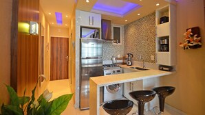 Une cuisine compacte dotée d’appareils électroménagers modernes, d’un four encastré et d’un évier.