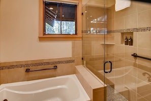 A modern bathroom with a bathtub, a glass shower enclosure, and a window with a view of trees. - Pine Ridge Estate (Cle Elum)