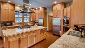 A modern kitchen with wooden cabinets, stainless steel appliances, and a large island. - Pine Ridge Estate (Cle Elum)