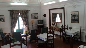 Un comedor con una mesa, sillas, un televisor y objetos decorativos.