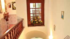 Una escalera con barandilla, una silla y un arreglo de girasoles en la parte superior.