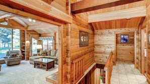 A log cabin interior with a living room, a staircase, and a dining area. - Yakima River Retreat (Cle Elum)