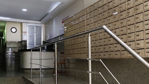 Eine Lobby mit einer Metalltreppe, einem Empfangsbereich und einer Wand voller Lagerkisten.