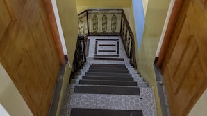 Un escalier orné de carreaux décoratifs, doté de portes en bois et de rampes en métal.