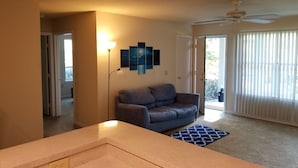 A living room with a sofa, a lamp, and a ceiling fan. - Condo near IMG Academy & Beaches (Bradenton)