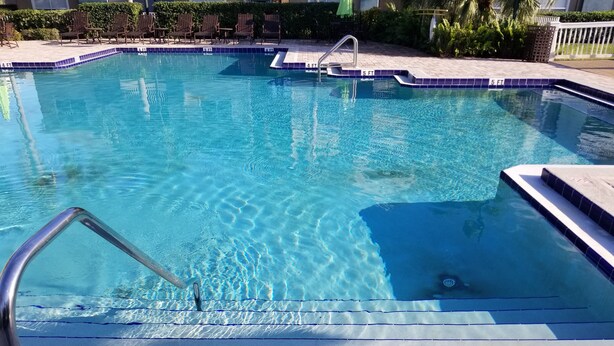 A swimming pool with clear blue water, marked depth lines, and a 5 ft. drain line. - Condo near IMG Academy & Beaches (Bradenton)