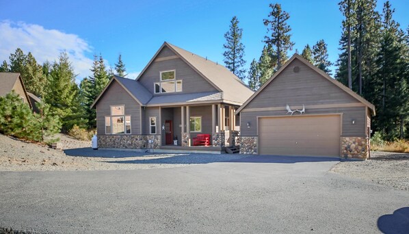 A two-story house with a stone foundation, a front porch, and a garage.