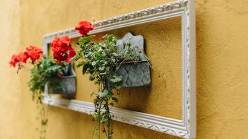 Un espejo con un marco decorativo fijado en una pared amarilla con textura.