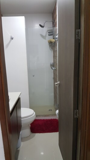 A compact bathroom with a toilet, a shower, and a sink. - Apartamento Mistral Cielo Mar (Cartagena)