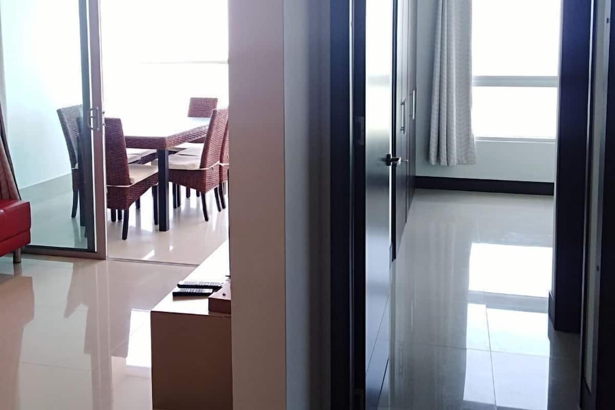 Ein modernes Hotelzimmer mit Glastür zu einem Essbereich, inklusive Tisch und Stühlen.