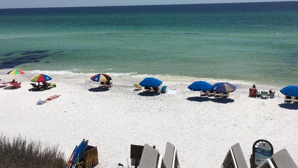A wooden boardwalk leading to a beach with several umbrellas and beach chairs. - Quaint Condo Seagrove Beach right fof 30A, quick walk to two beach accessPo (Santa Rosa Beach)