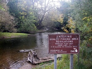 A sign indicating regulations for entering a quality fishing area, including a creel limit and prohibition of artificial flies. - Northern Memories Couples Getaway! Open 24/7: Jacuzzi/Grill/Firepit/Pet friendly (Grayling)