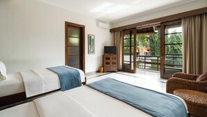 A hotel room with two beds, a television, a wicker chair, and a view of the outdoors. - Kecapi Villa Seminyak (Seminyak)