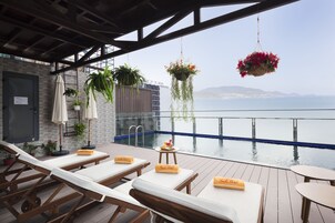 室外游泳池，06:00 至 22:00 开放，池畔遮阳伞，日光浴躺椅