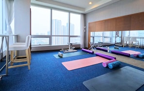 A spacious room with large windows, a yoga mat, a chair, and exercise equipment. - Bridge Hotel Incheon Songdo (Incheon)