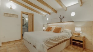 Camera da letto con un letto, un comodino e un soffitto in legno.