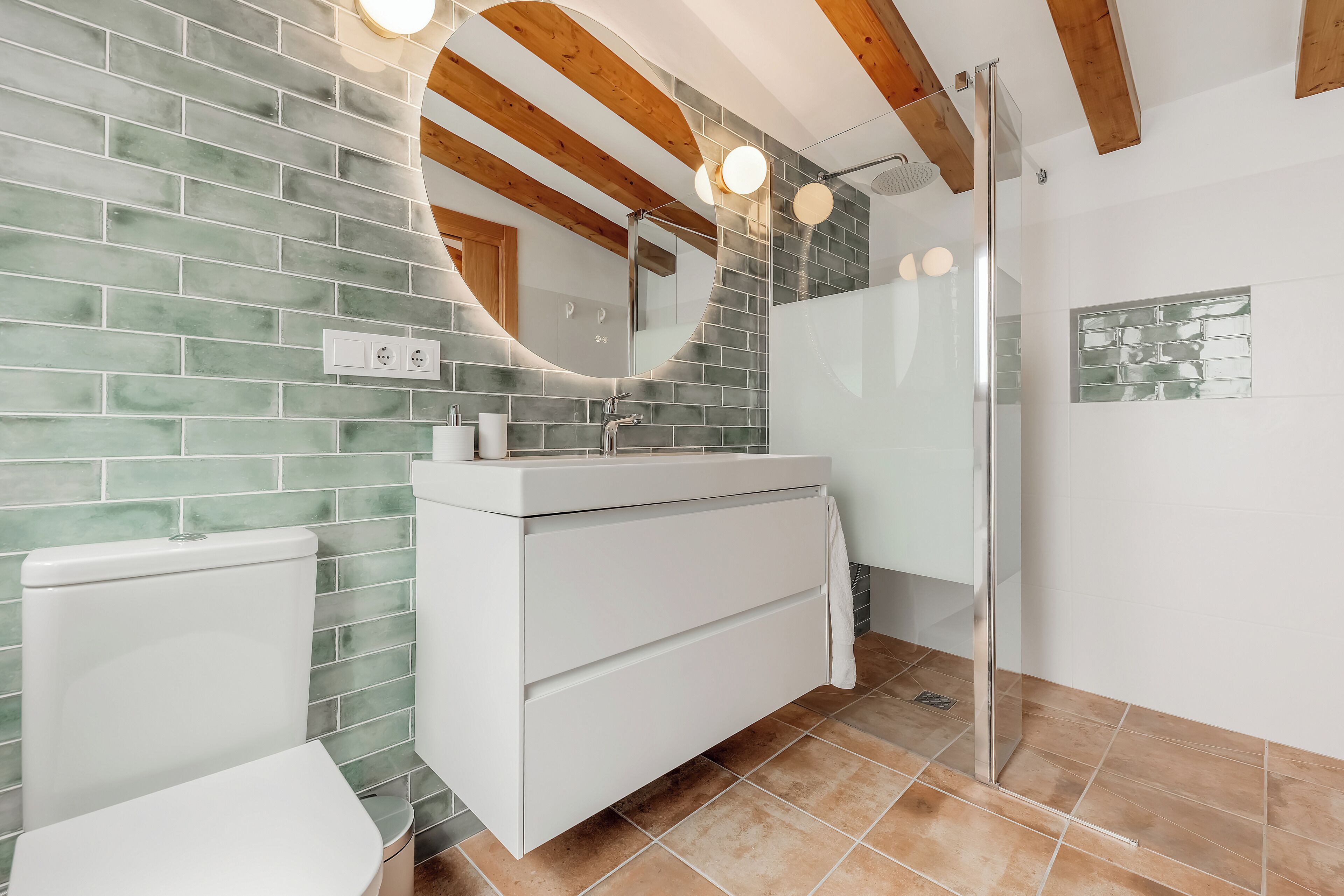 A bathroom with a white sink, mirror, and shower.