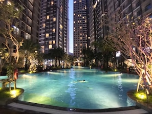 Una piscina rodeada de altos edificios residenciales de noche.