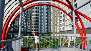 A modern building with a unique red and white structural design. - Sunflower Luxury Apartment (Ho Chi Minh City)