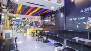 Interior de restaurante con techo colorido, zona de bar y asientos.