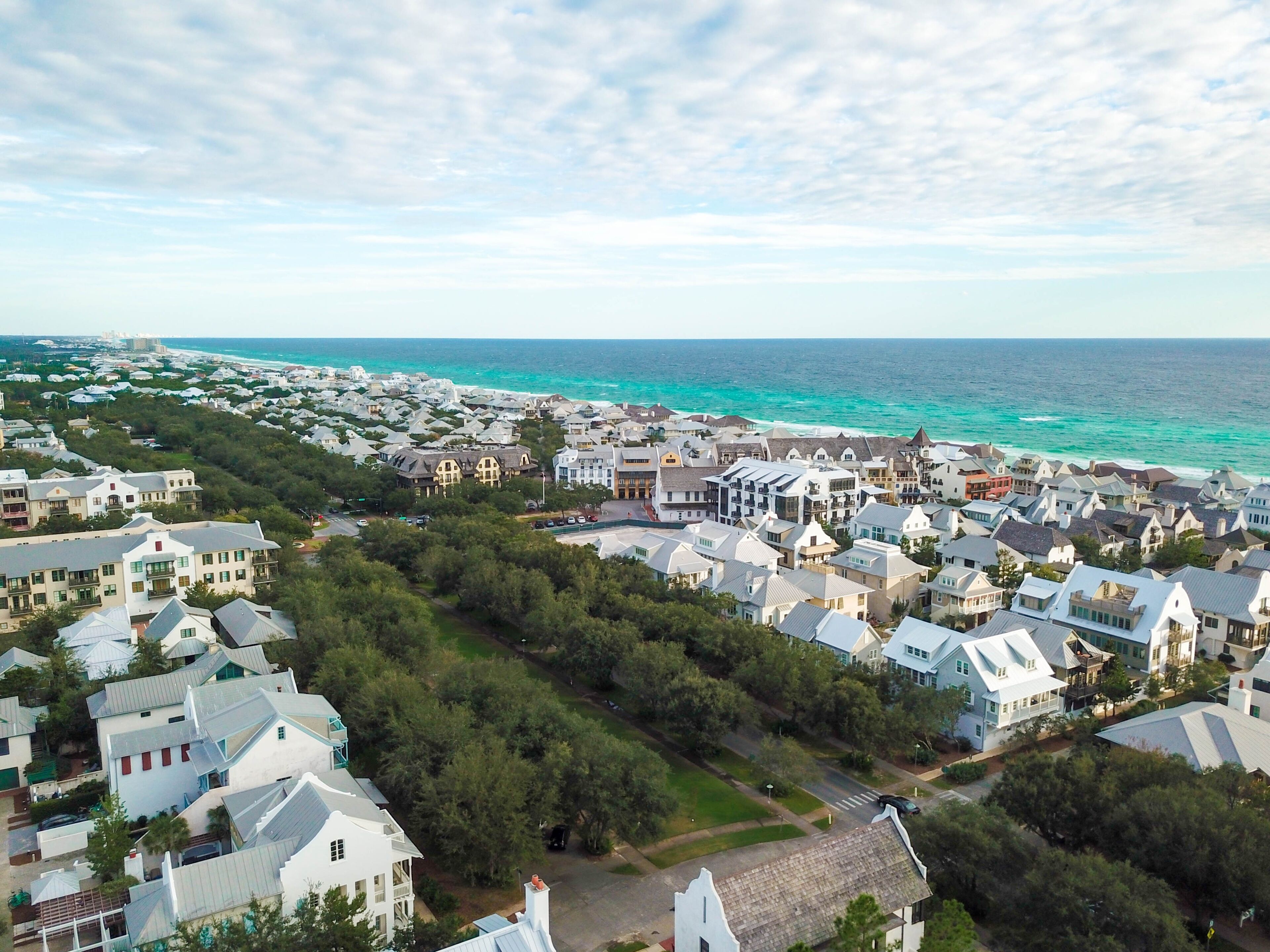 A coastal residential area with houses, a road, and a beach.