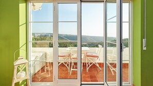 A balcony with a table and chairs, a lantern, and a view of the landscape. - CORAL VILLA, a charming landscape close to the beach, best choice for families (Carvoeira)