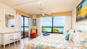 A bedroom with a large bed, a desk, and a chair. It has a view of the ocean through large windows. -  Sunset Beach - Ocean front with stunning sea views, WI-FI, AC. (Oistins)