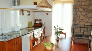 Een keuken met een houten tafel, een gootsteen en een stenen muur.